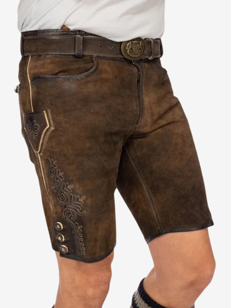 Side view of brown leather lederhosen worn with a white shirt, featuring embroidered detailing and traditional buttons along the hem.