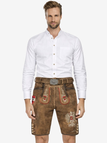 Front view of a man wearing brown lederhosen with red and white embroidery, paired with a white shirt and decorative belt.