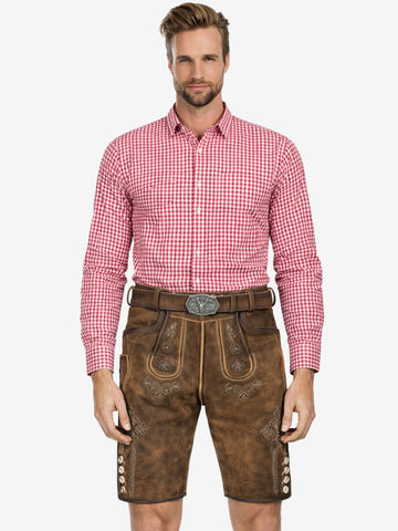 Man wearing brown leather lederhosen shorts with embroidered details and a red checkered shirt.