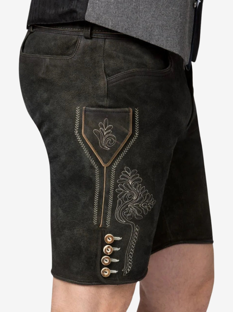 Close-up side view of black suede lederhosen with light embroidery, decorative stitching, side pocket, and traditional buttons.