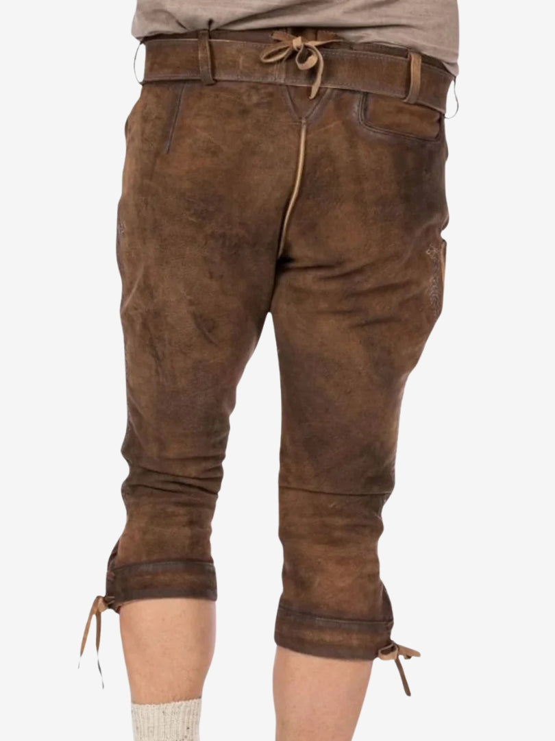 Back view of brown leather bundhosen showing waistband tie detail, belt loops, and knee-length design with side ties.