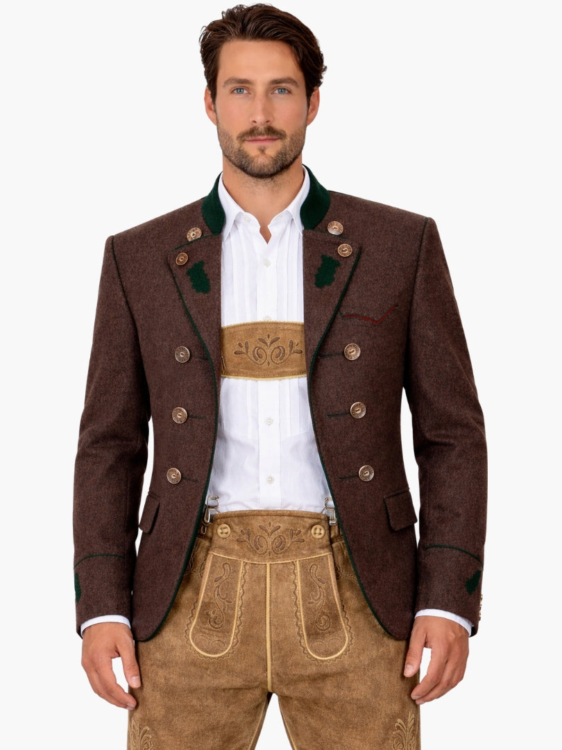 Man wearing brown double-breasted Bavarian Trachten jacket with green trim, paired with beige lederhosen and white shirt for a traditional Oktoberfest outfit.