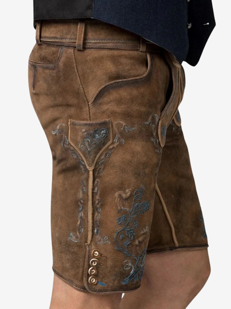 Side view of brown suede lederhosen with blue embroidery, featuring floral patterns, a side pocket, and decorative buttons near the hem.