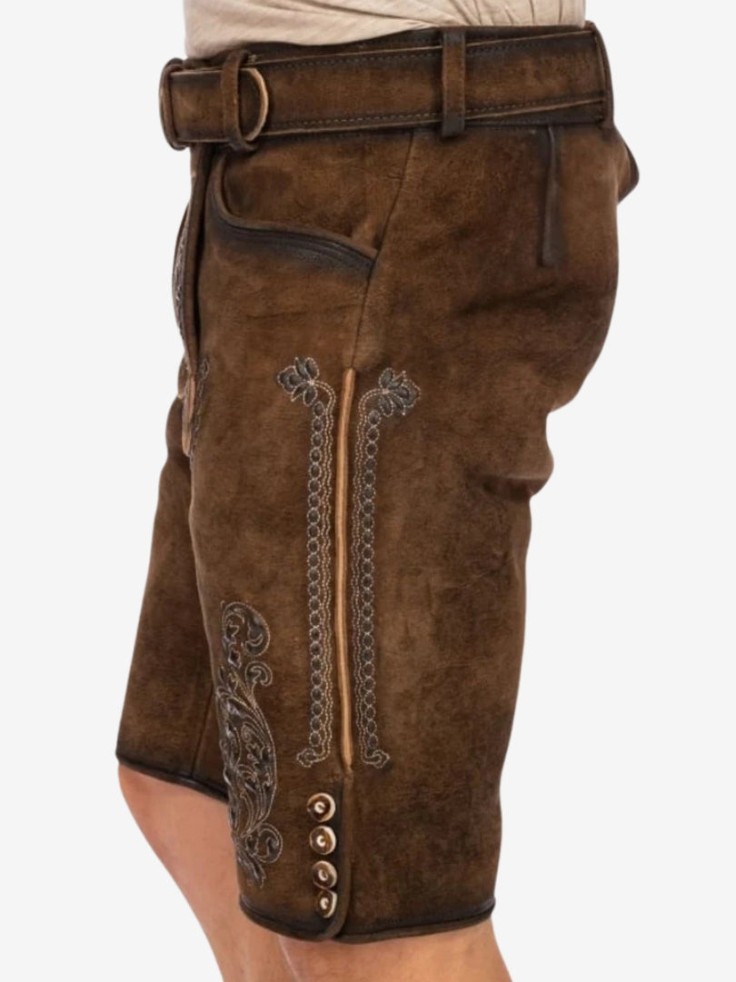 Side angle of brown leather lederhosen showing detailed embroidery, vertical stitching, and decorative buttons along the hem.