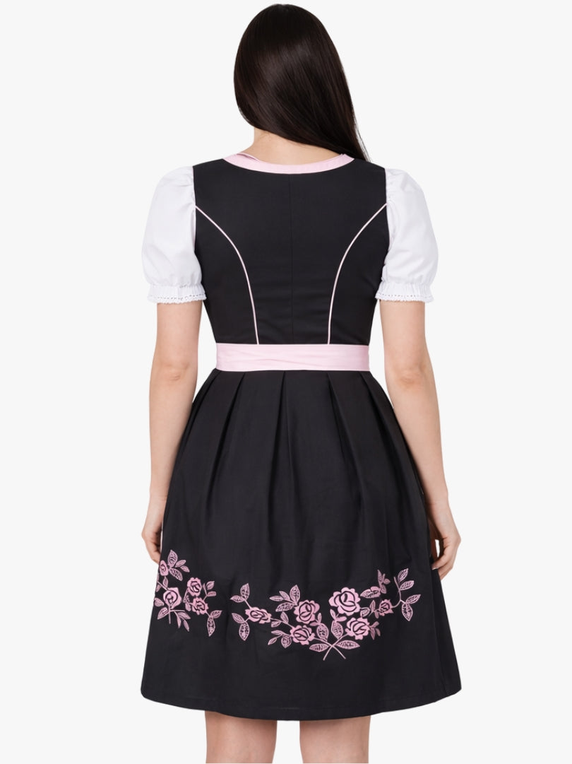 Front view of women's black and pink Bavarian dirndl dress with white blouse, lace-up bodice, and pink apron in traditional Oktoberfest style.