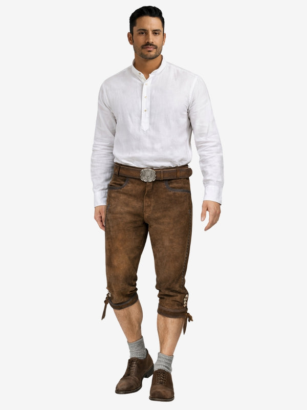 Man wearing brown bundhosen with a white shirt, belt, socks, and traditional shoes in a full-length front view.