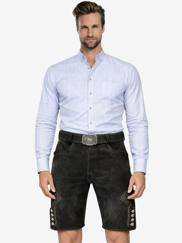 Man wearing black lederhosen with subtle embroidery, paired with a light blue shirt and traditional belt buckle.