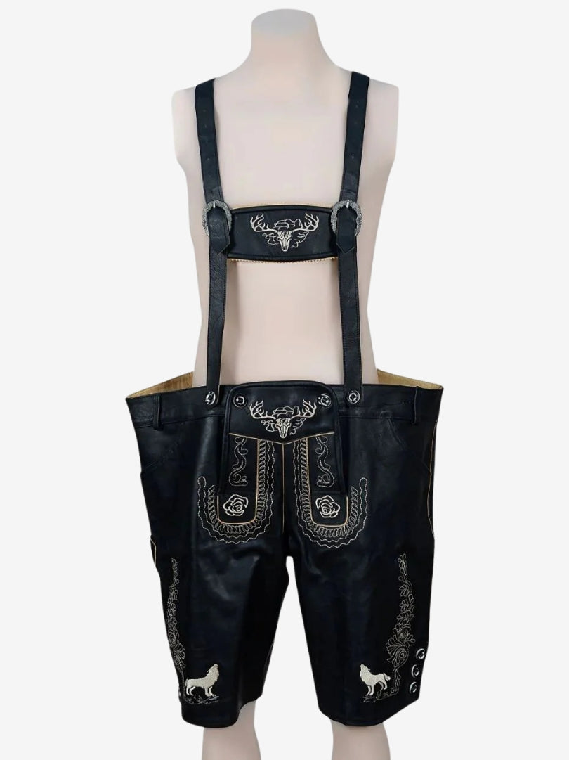 Black lederhosen with suspenders displayed on a mannequin, showing embroidered front panel and decorative stitching.