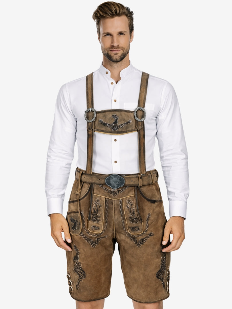 Man wearing brown lederhosen with traditional embroidery and suspenders, paired with a white shirt.