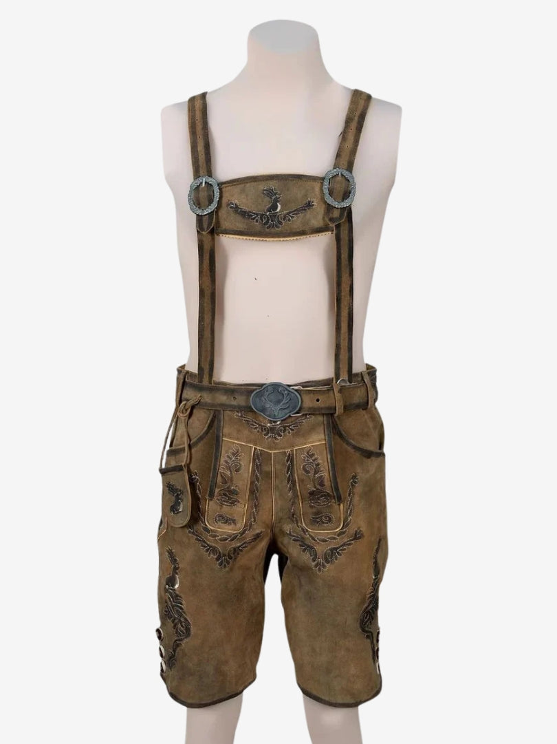Brown lederhosen with suspenders displayed on a mannequin, highlighting front flap and detailed embroidery.