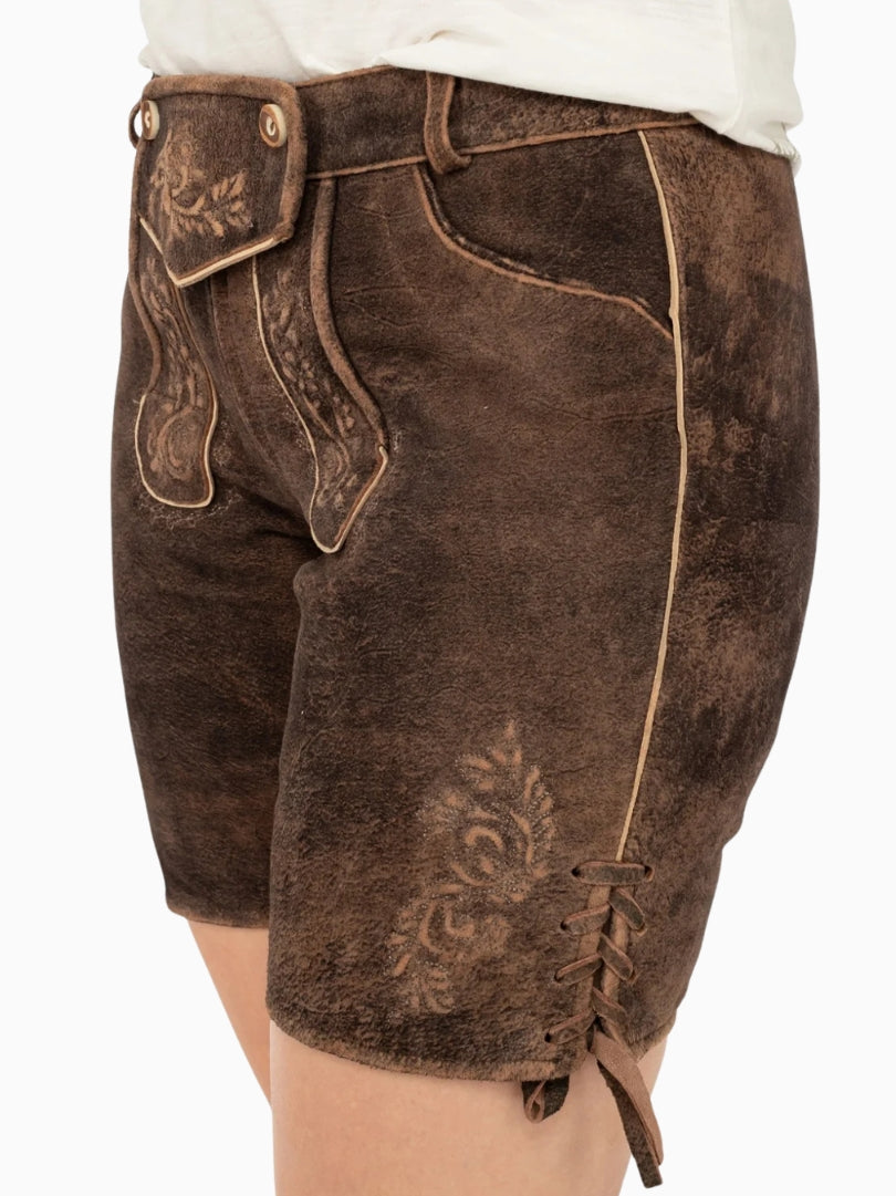 Side view of dark brown traditional lederhosen style shorts with embroidered floral detailing, contrast piping, and side lace-up detail on a textured leather finish.