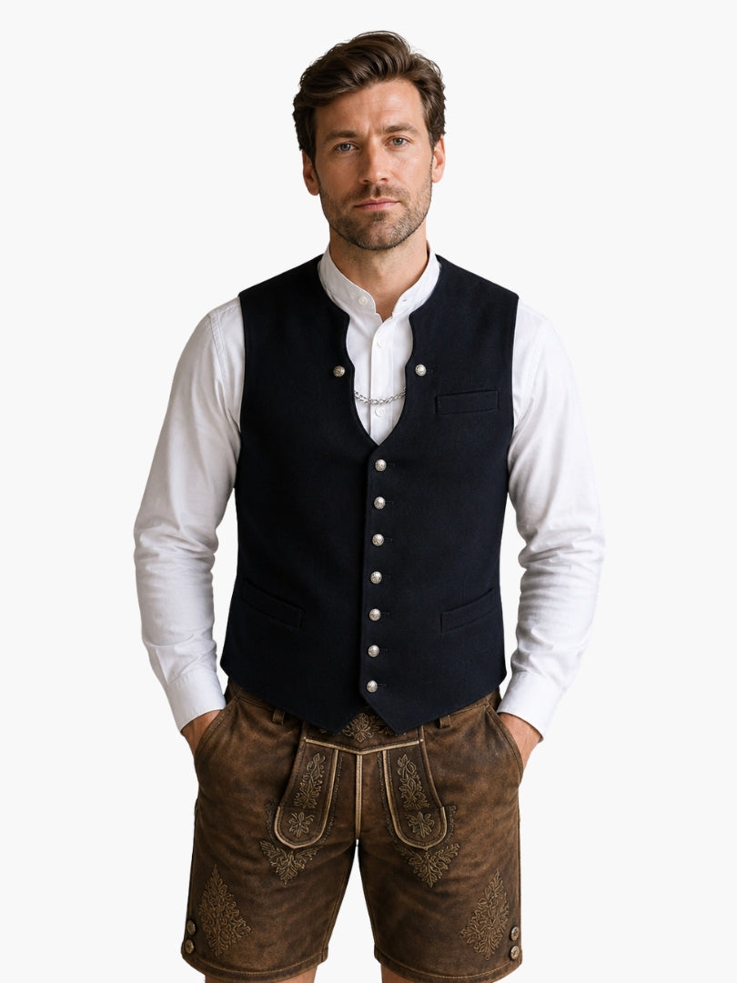 Men’s black Oktoberfest vest with traditional buttons, worn over white shirt and paired with leather lederhosen shorts.