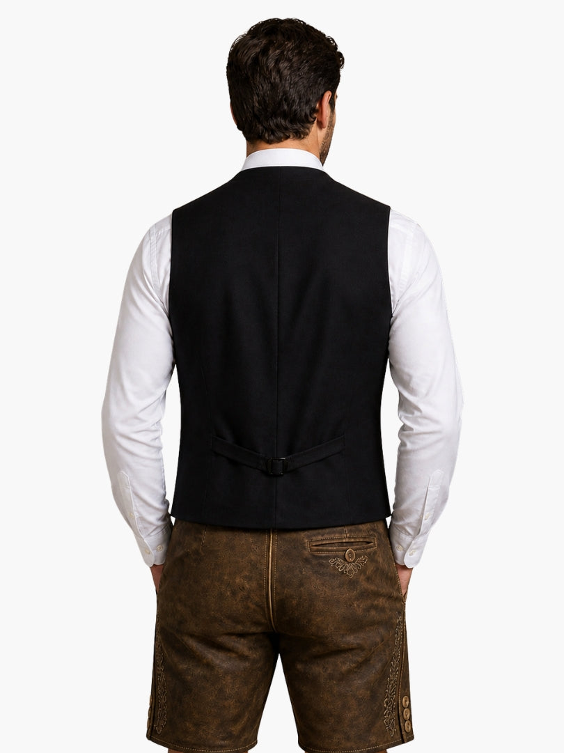 Back view of men’s classic brown Oktoberfest vest with adjustable strap, paired with traditional embroidered leather lederhosen shorts.