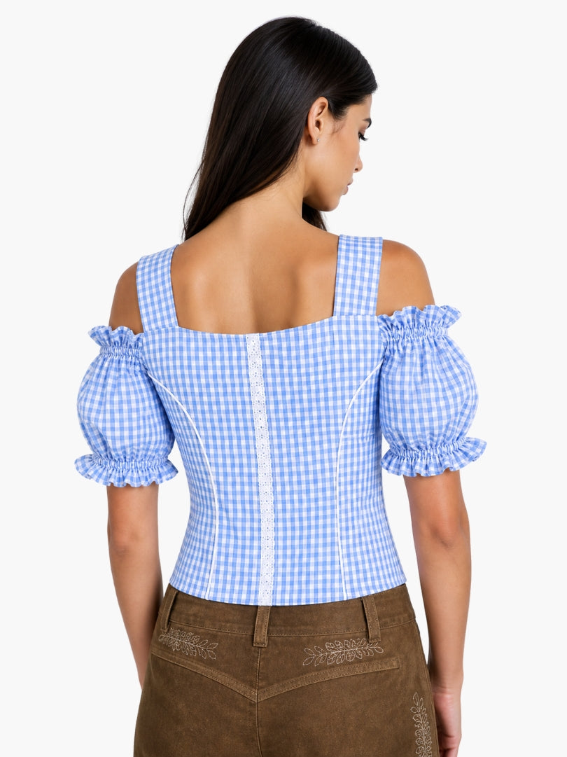 Women’s light blue gingham Oktoberfest blouse with puff sleeves, lace accents, and fitted bodice styled with traditional lederhosen.