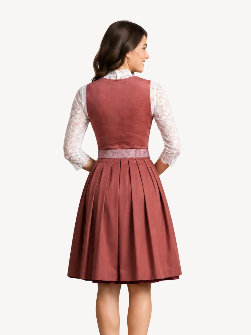 A woman shown from the back wearing a sleeveless dusty rose dress with a pleated skirt, layered over a white lace long-sleeve top, against a plain light background.