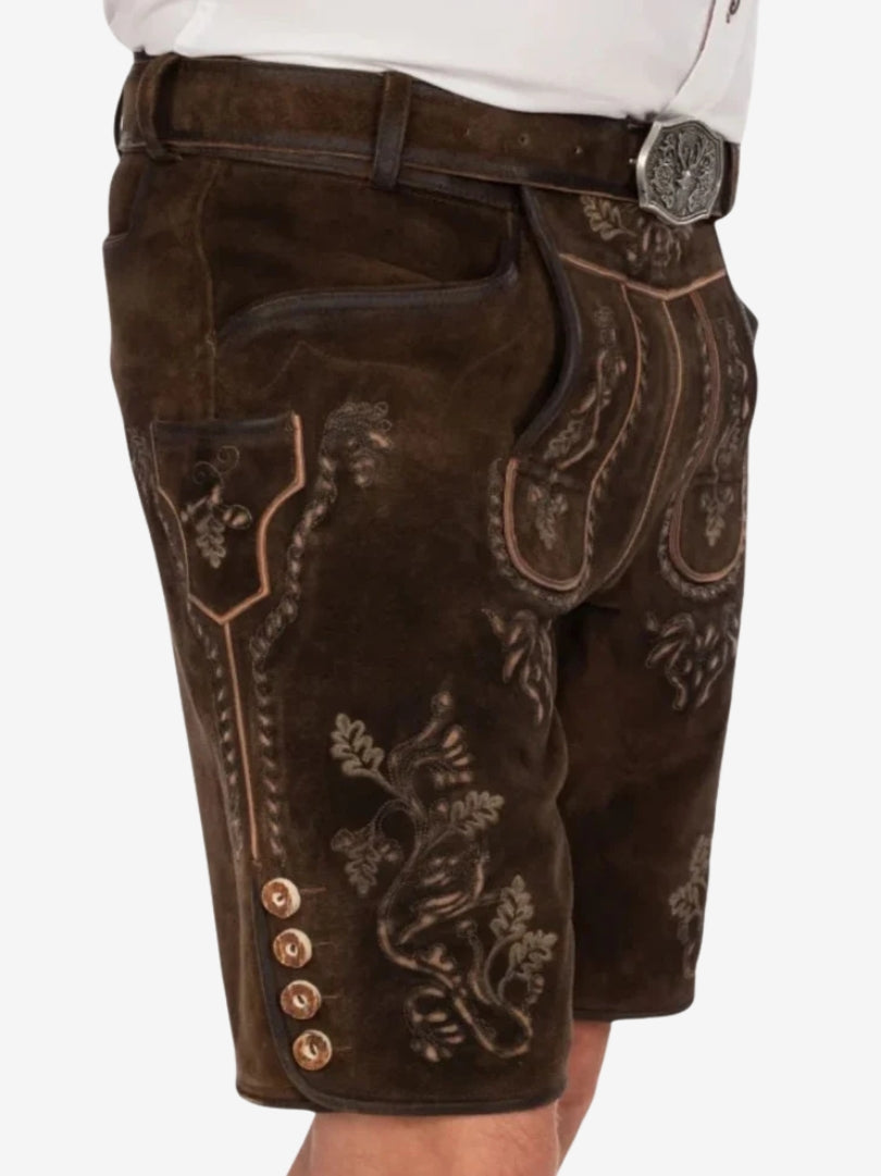 Side view of embroidered lederhosen featuring intricate floral patterns, front flap design, and traditional horn-style buttons along the leg.