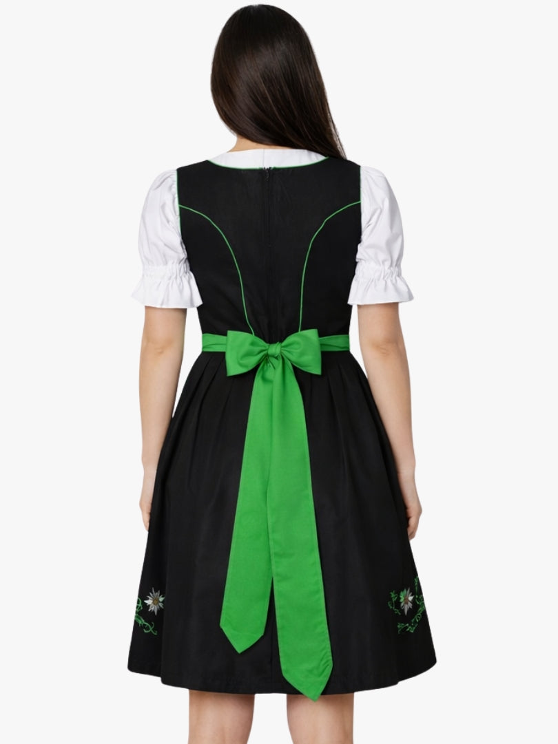 Back view of women's traditional black dirndl dress with white puff sleeve blouse and bright green apron tied with bow.