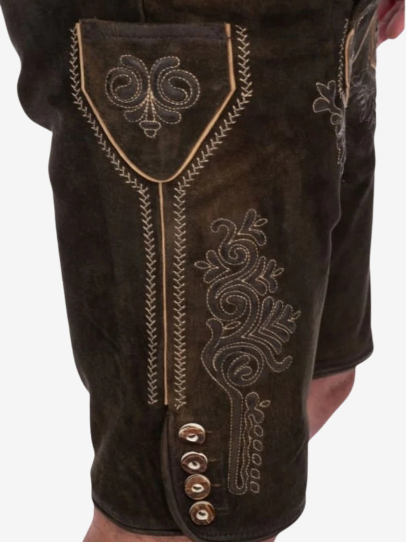 Close-up of intricate embroidery and button detailing on the thigh of dark brown lederhosen.