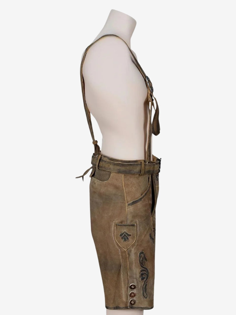 Opposite side view of brown lederhosen with suspenders, highlighting embroidery, pocket flap, and traditional buttons.