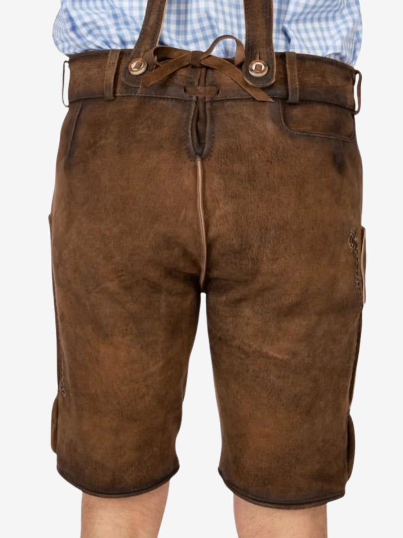Rear view of brown lederhosen featuring a smooth leather finish, adjustable back tie, and suspenders attached at the waist.