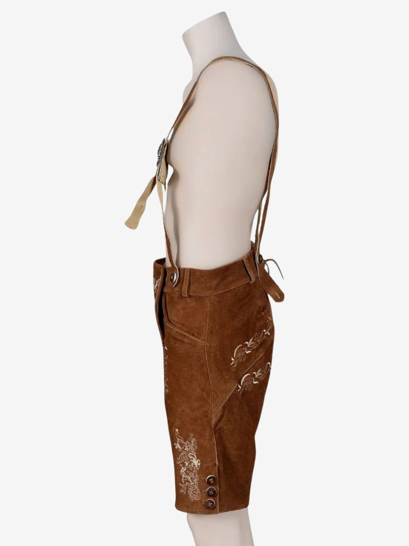 Opposite side view of brown lederhosen highlighting pocket design, stitching, and decorative embroidery.
