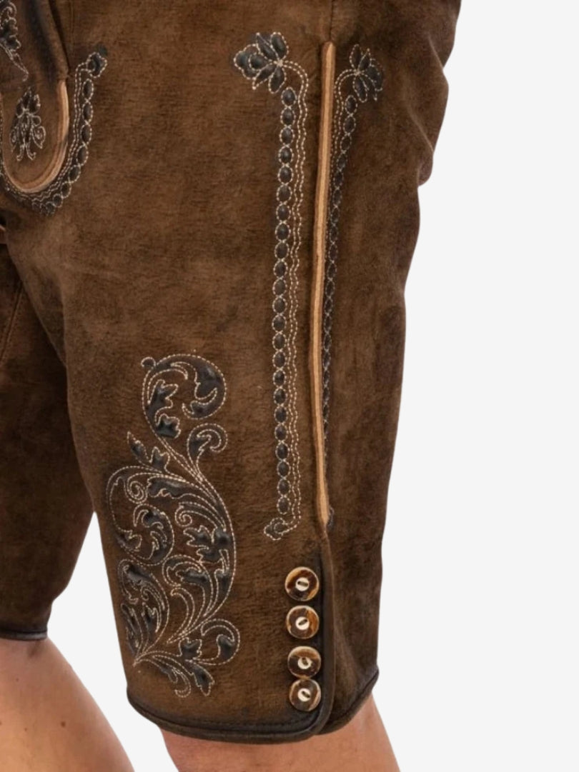 Close-up of lederhosen thigh area highlighting intricate floral embroidery and textured leather finish.