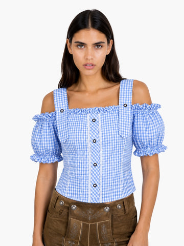Women’s light blue gingham Oktoberfest blouse with puff sleeves, lace accents, and fitted bodice styled with traditional lederhosen.
