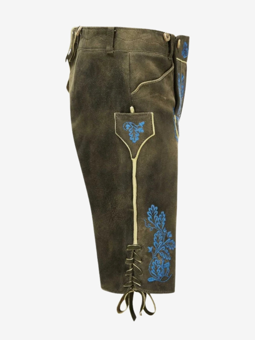 Side view of lederhosen featuring a small utility pocket, blue embroidered leaf design, and adjustable lace-up leg opening.