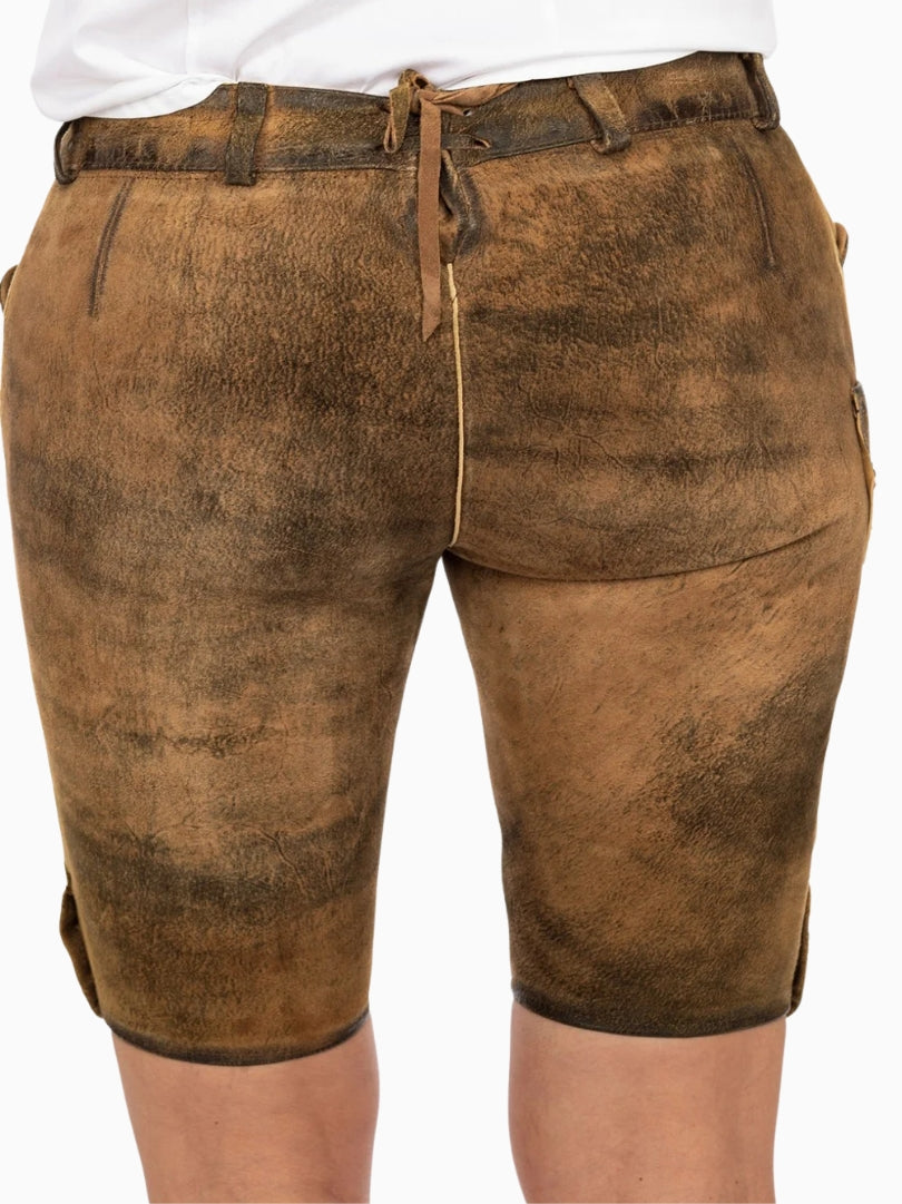 Back view of rustic brown traditional lederhosen-style shorts with a distressed leather texture, adjustable back lace detail, and belt loops, worn with a white top.