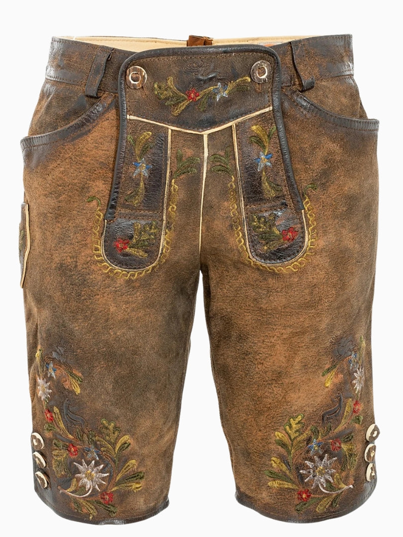 Front view of rustic brown traditional lederhosen-style shorts featuring colorful floral embroidery, decorative front flap with buttons, and a textured leather finish.