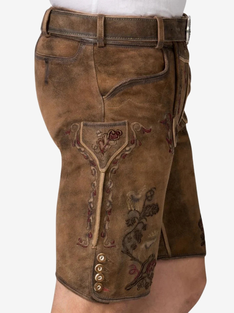 Close-up side view of lederhosen highlighting embroidered patterns, side pocket, and decorative buttons near the hem.