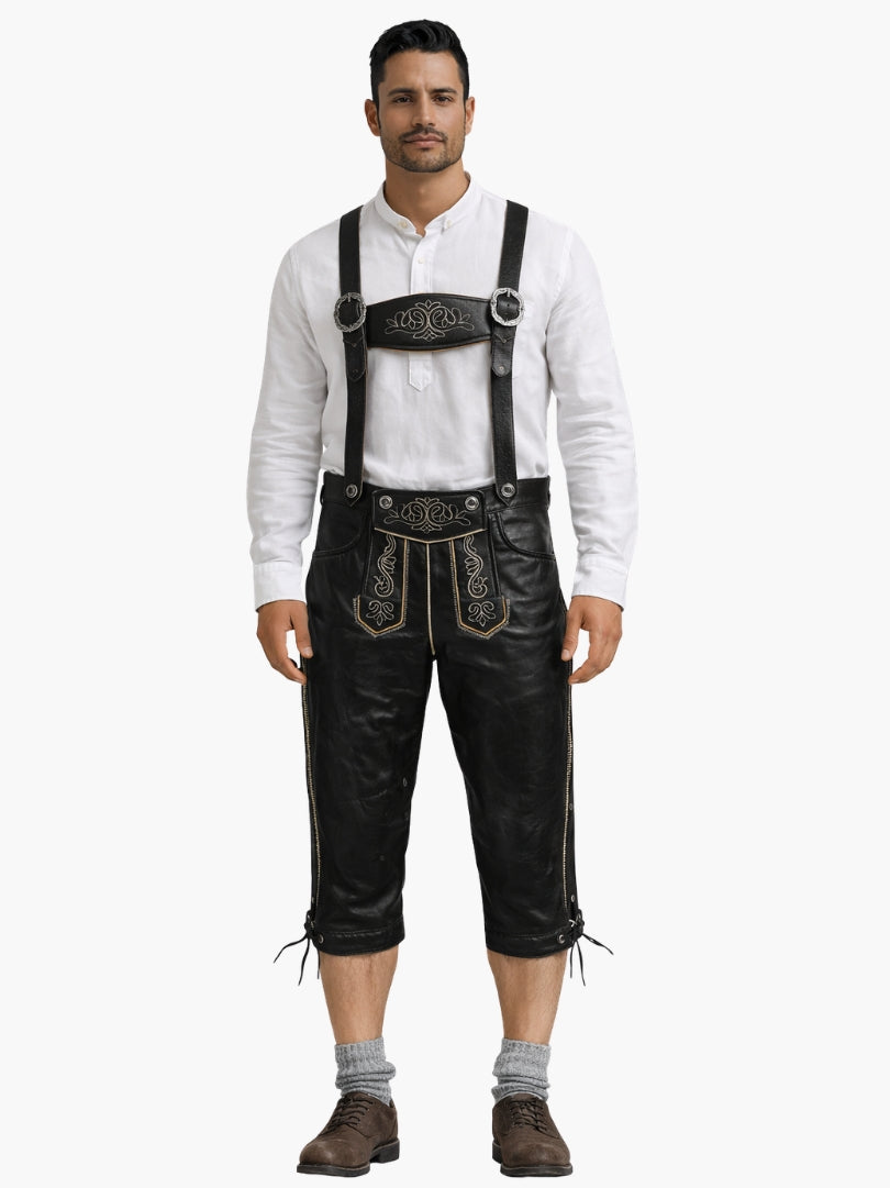 Man wearing black leather bundhosen with suspenders, paired with a white shirt, grey socks, and brown shoes in a front-facing pose.