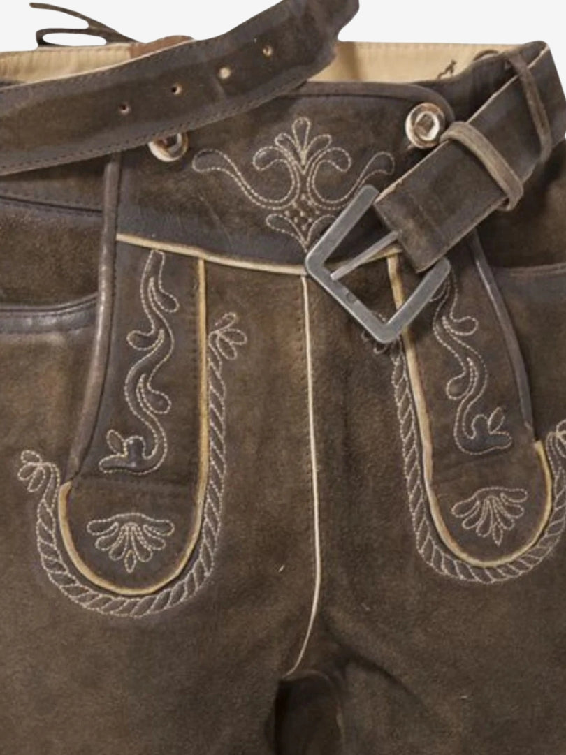 Close-up of bundhosen front showing decorative embroidery, button accents, and attached belt with metal buckle.