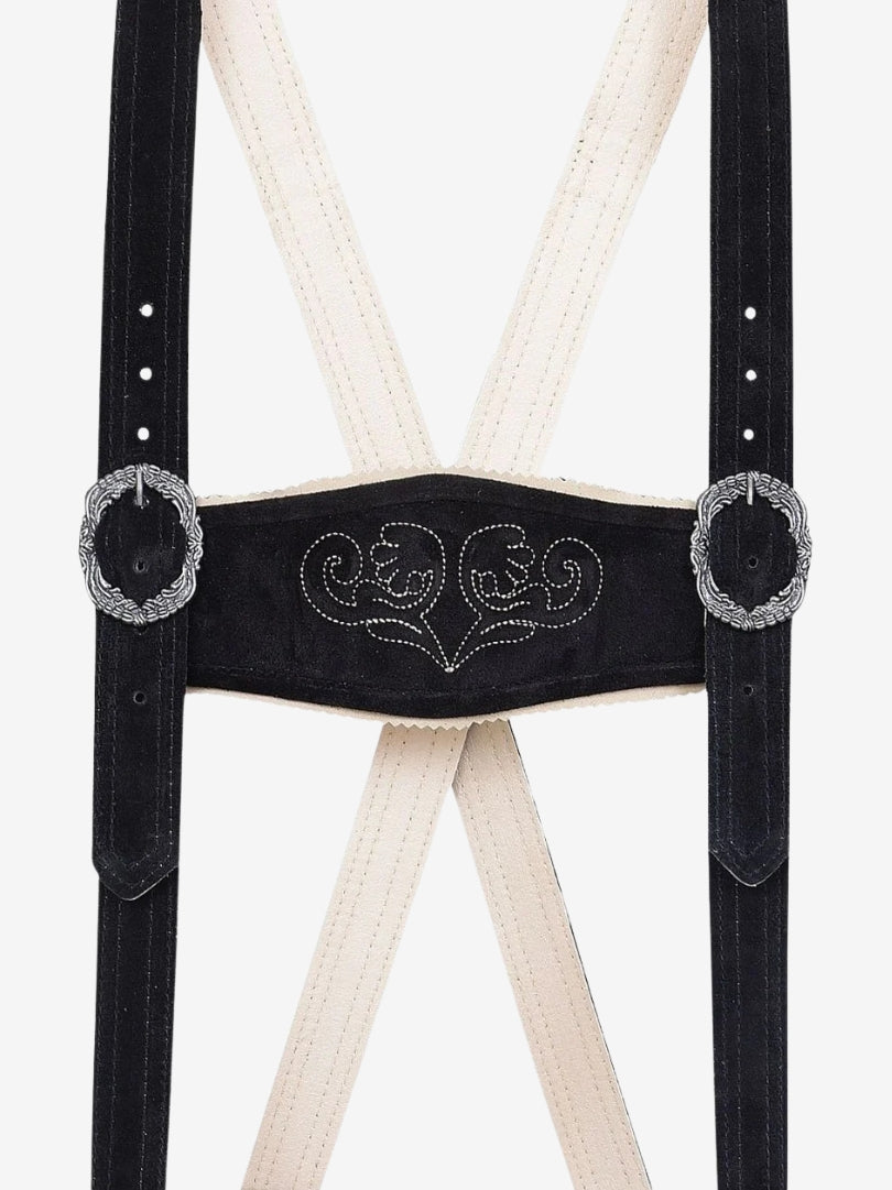 Close-up of black leather suspenders with decorative embroidery and metal buckle accents on a cream backing.