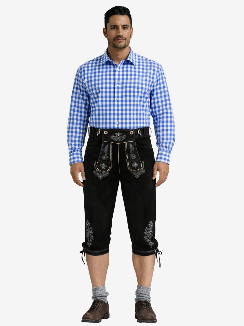Man wearing black leather bundhosen with a blue checkered shirt, socks, and shoes in a full-length front view.