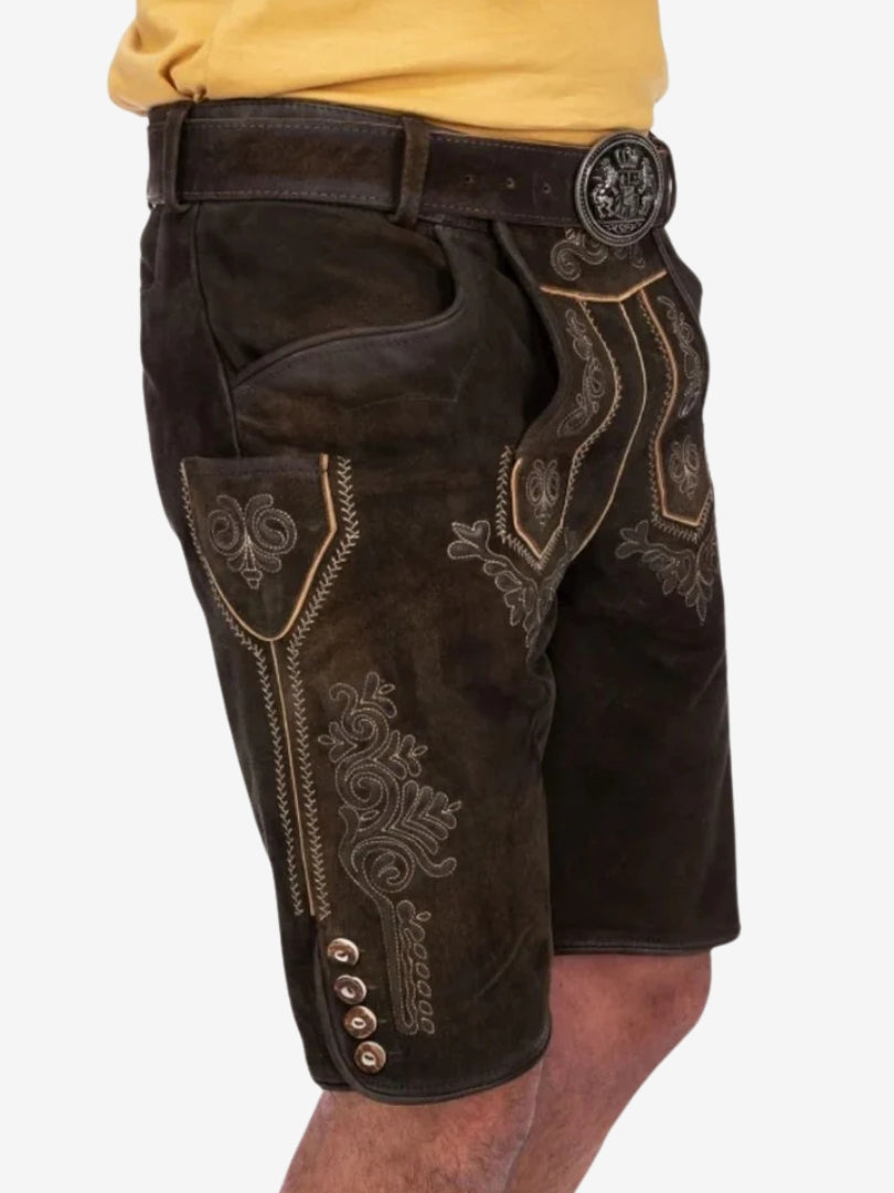 Side angle of dark brown lederhosen showing embroidery patterns, front flap, and button accents on the leg.