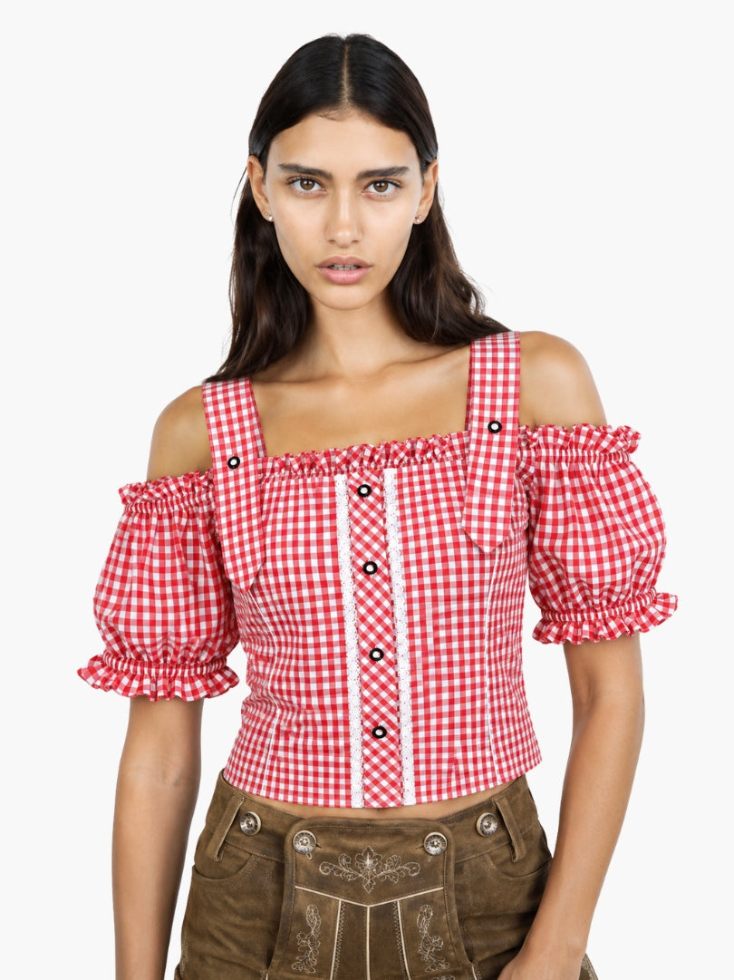 Women’s red gingham Oktoberfest blouse with puff sleeves, lace detailing, and fitted bodice styled with traditional lederhosen.