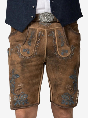 Close-up of lederhosen front showing detailed blue embroidery, decorative flap, and a belt with engraved metal buckle.