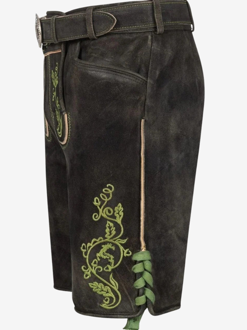 Side angle of black lederhosen featuring green embroidered patterns, lace-up leg detail, and traditional stitching.