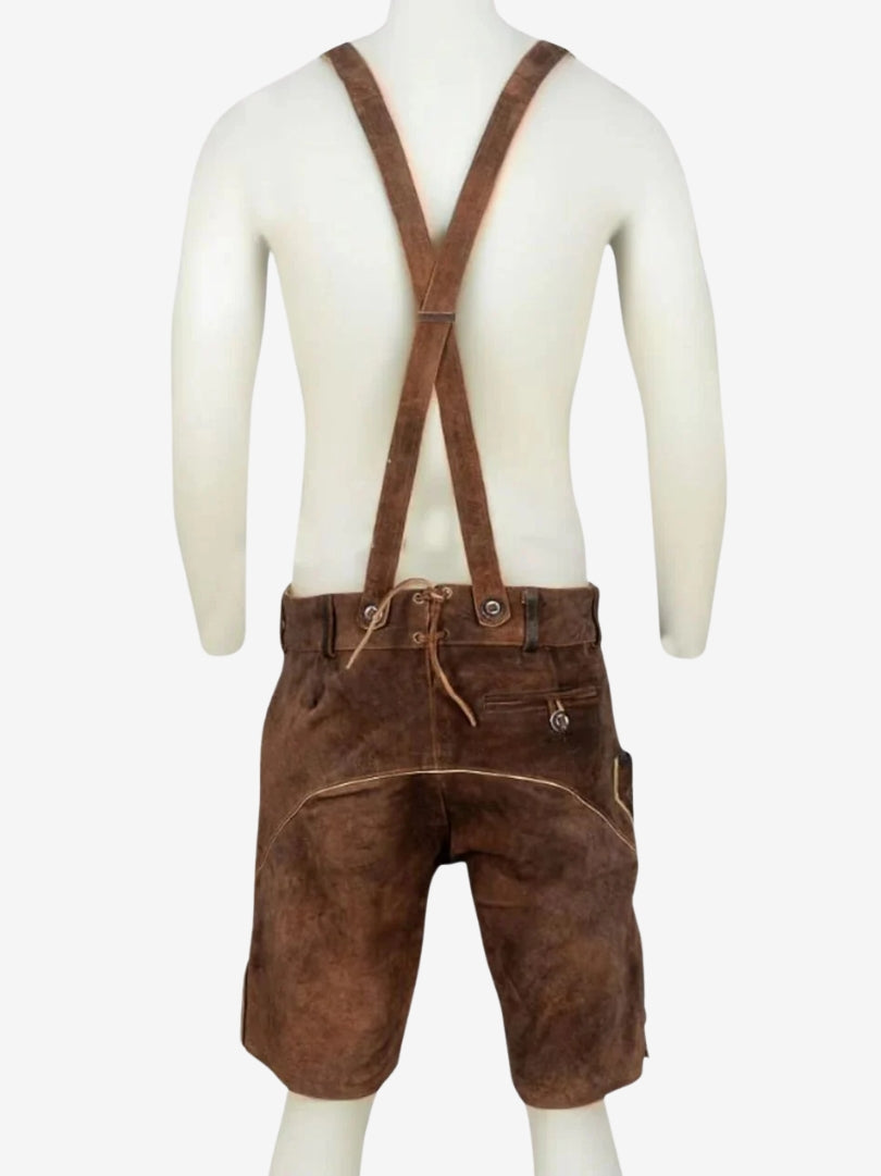 Back view of brown lederhosen with suspenders on a mannequin, showing crossed straps and smooth suede finish.