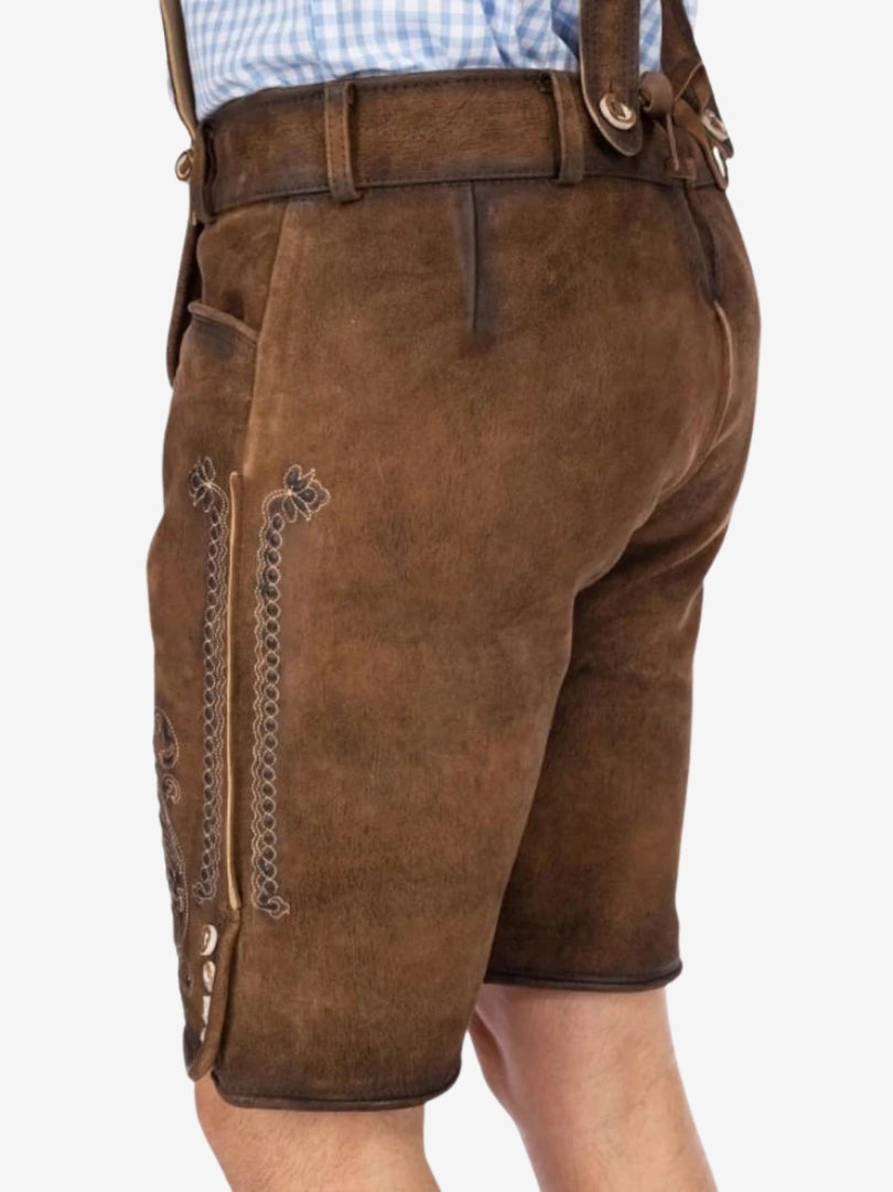 Close-up side-back view of brown lederhosen with stitched vertical patterns and button accents near the hem.