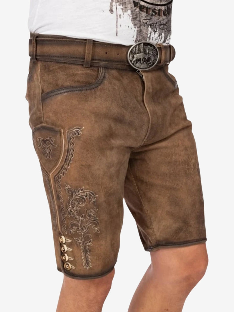 Close-up front view of brown lederhosen with decorative stitching, belt buckle, and embroidered patterns.
