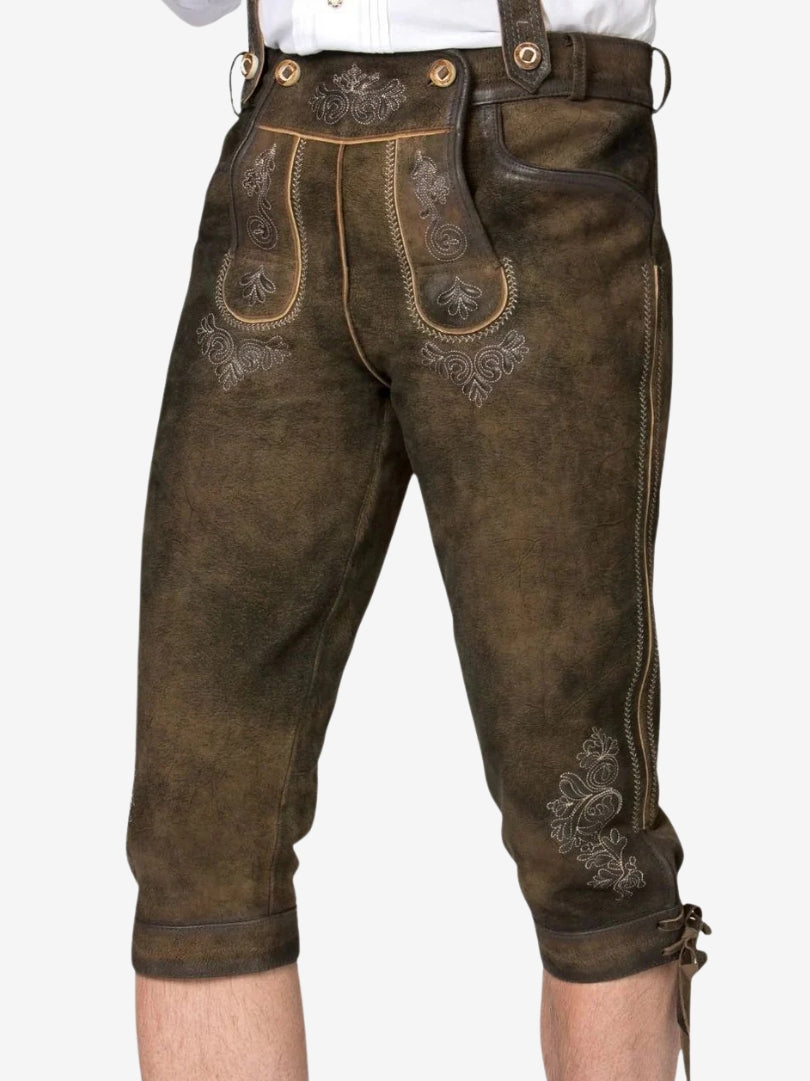 Angled close-up of brown bundhosen showing detailed embroidery on the front flap and side leg.