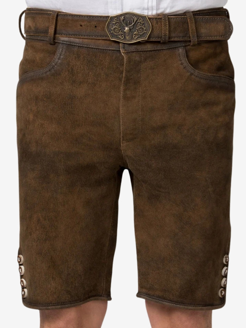 Close-up of brown lederhosen waist area showing textured suede, belt with engraved deer buckle, and front pocket design.