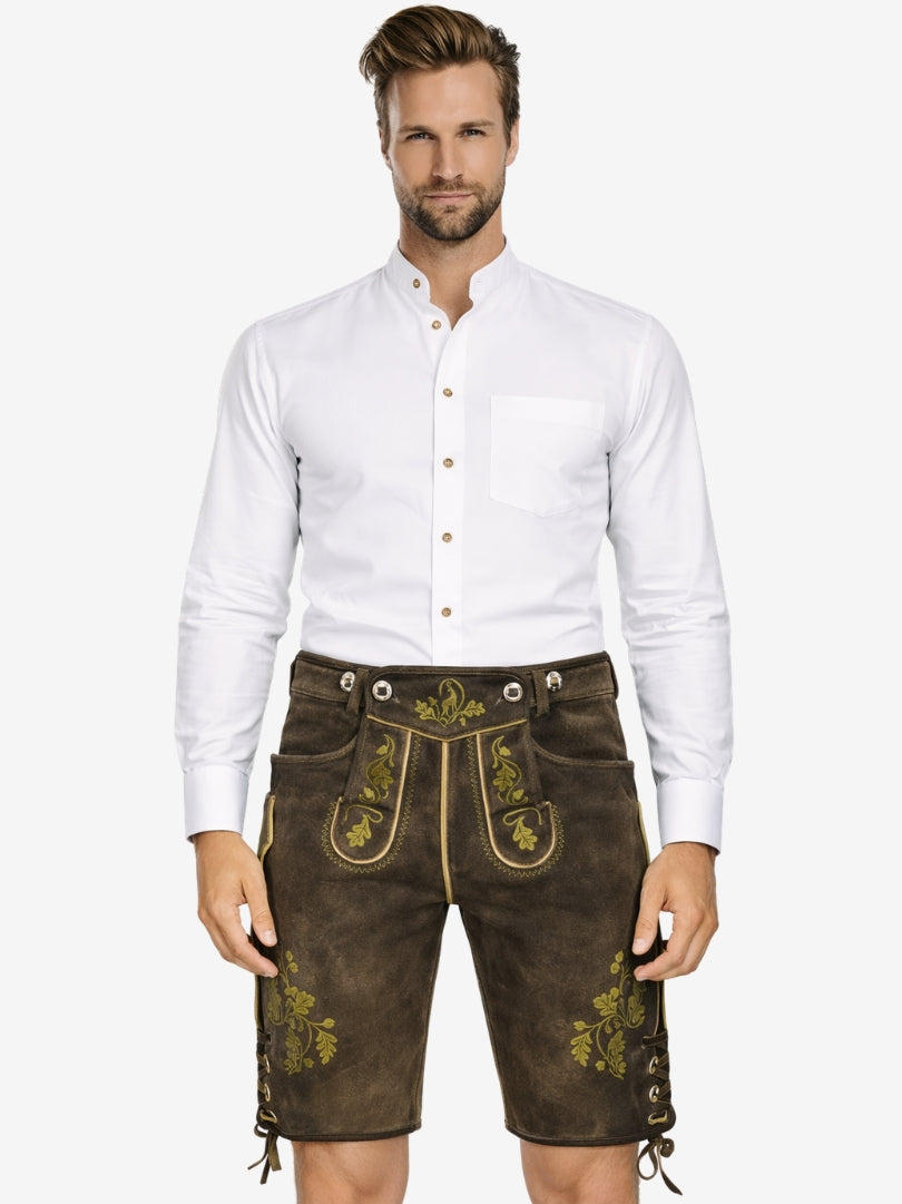Man wearing olive green embroidered lederhosen with a white shirt, showcasing a classic Bavarian outfit.