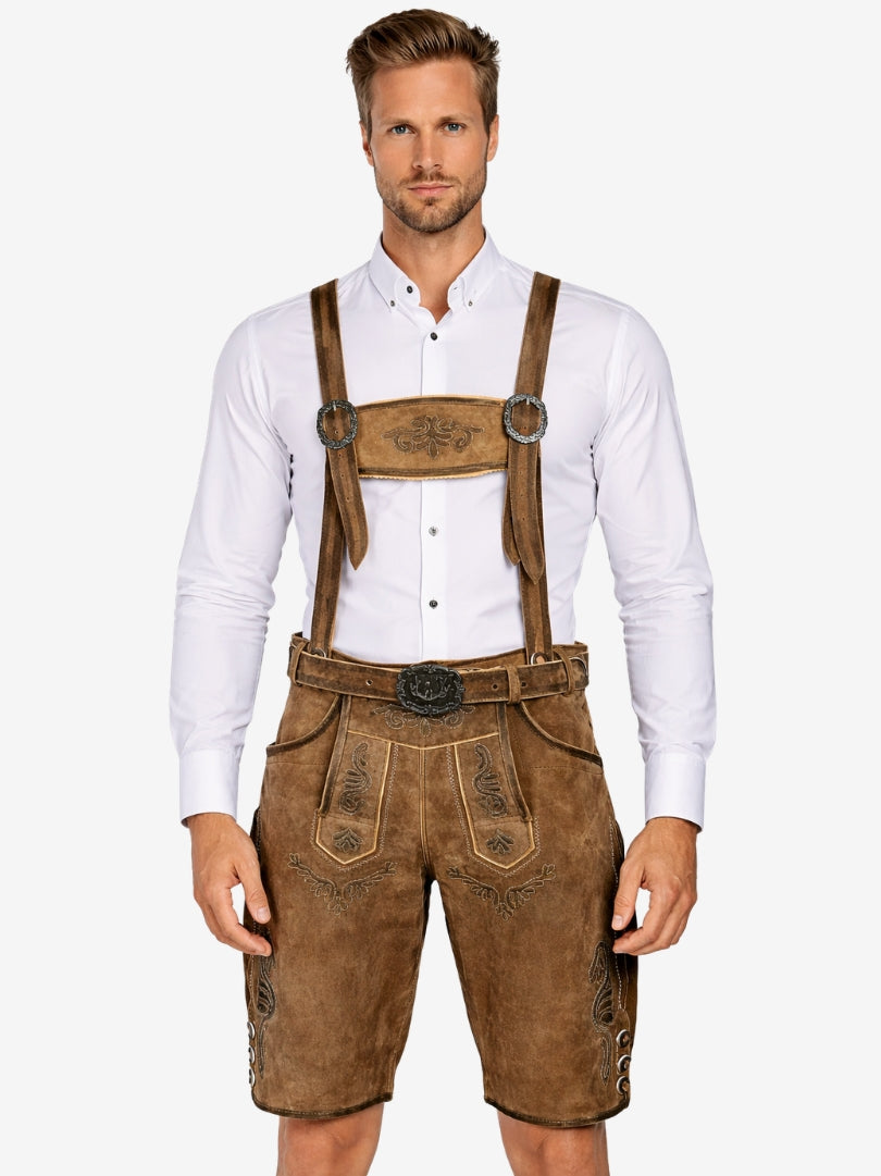 Man wearing brown lederhosen with suspenders and embroidery, paired with a white shirt and traditional belt.