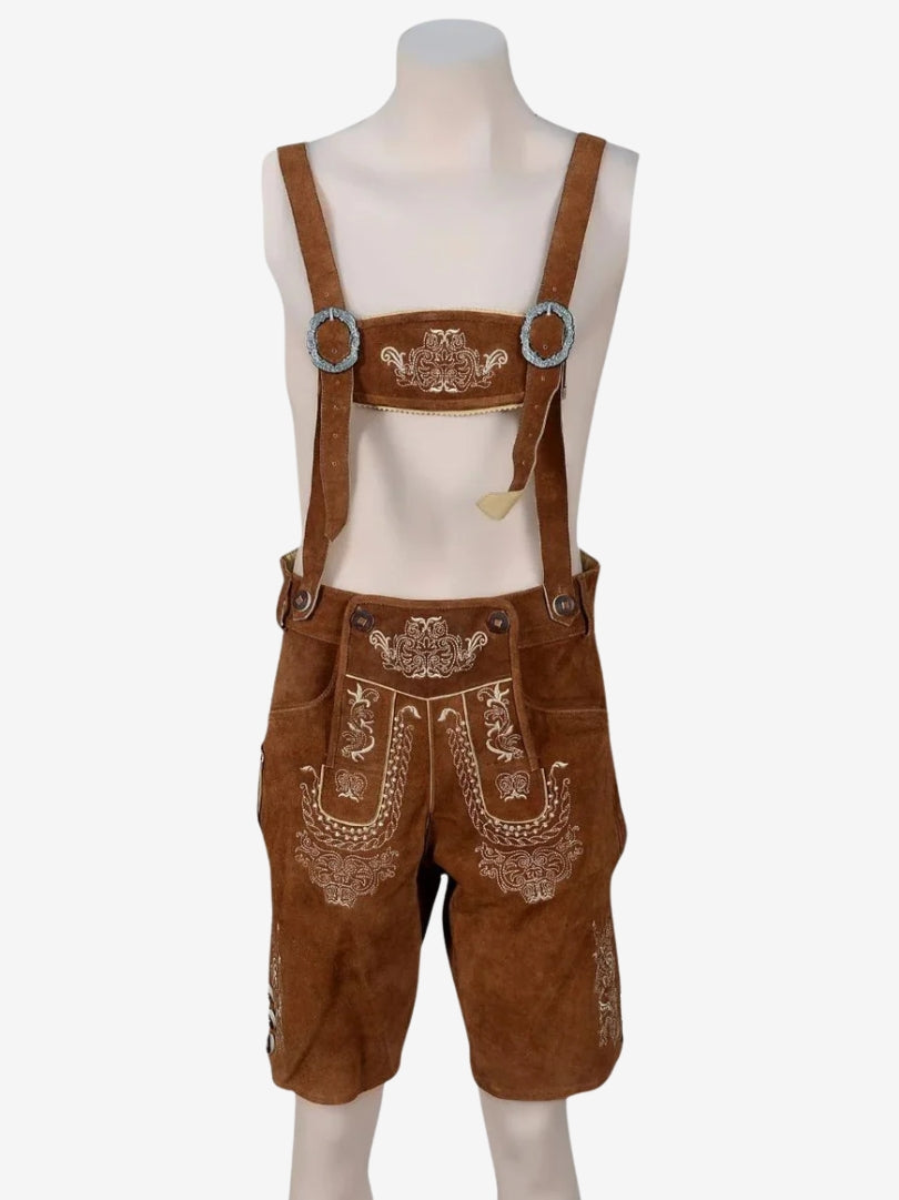 Brown lederhosen with suspenders displayed on a mannequin, showing detailed front embroidery and flap design.