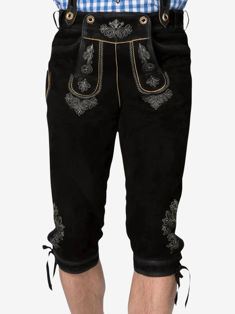 Close-up of black bundhosen worn with suspenders, highlighting embroidered front panel and knee-length fit.