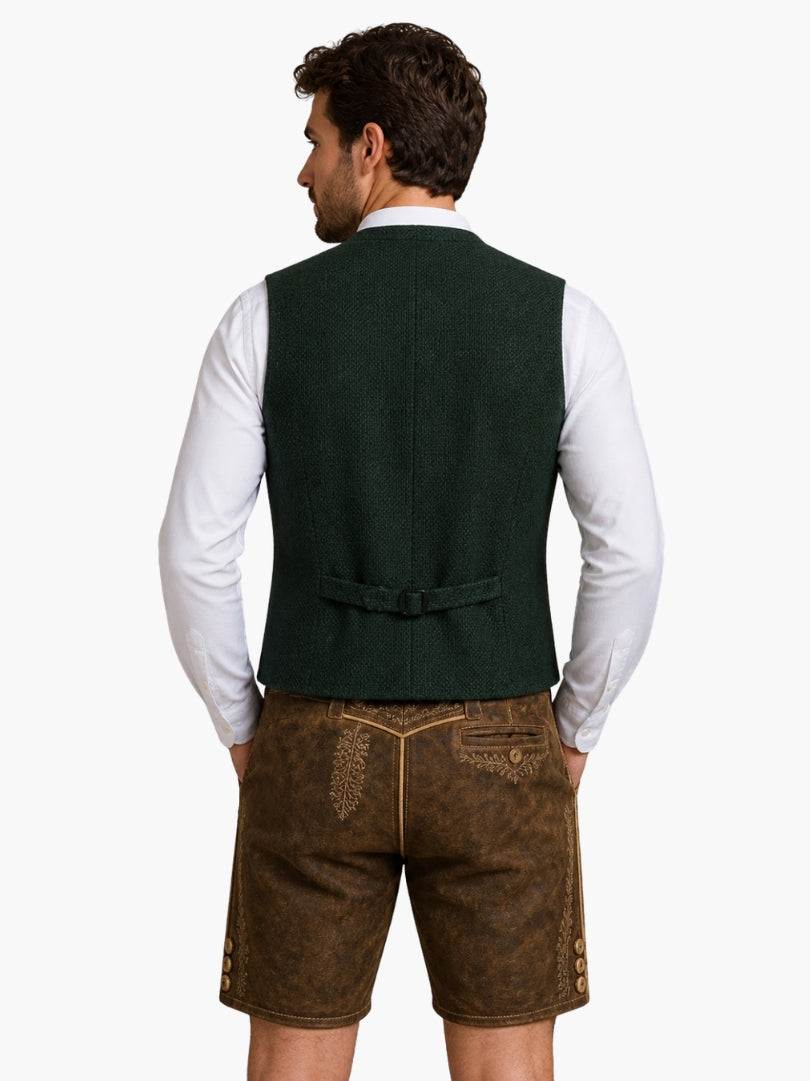 Rear view of dark green Bavarian vest with adjustable back strap, styled with embroidered lederhosen shorts for Alpine outfit.