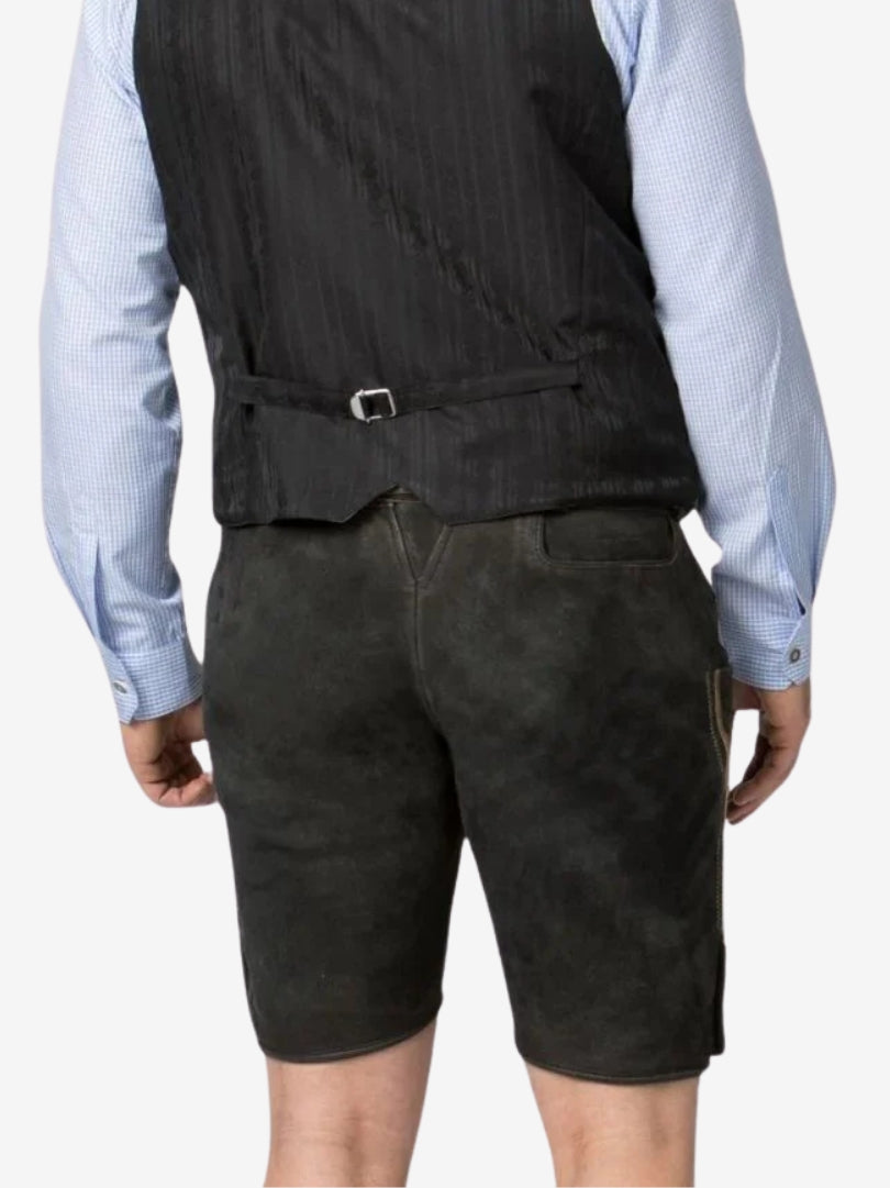Rear view of black lederhosen worn with a shirt and vest, showing a smooth suede finish and back pocket detail.